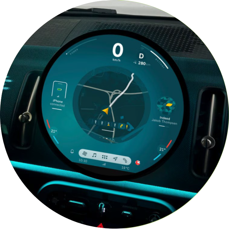 Closeup view of the dashboard and 9.4” round center information OLED display in a MINI Countryman S ALL4, from the perspective of the front passenger’s seat.