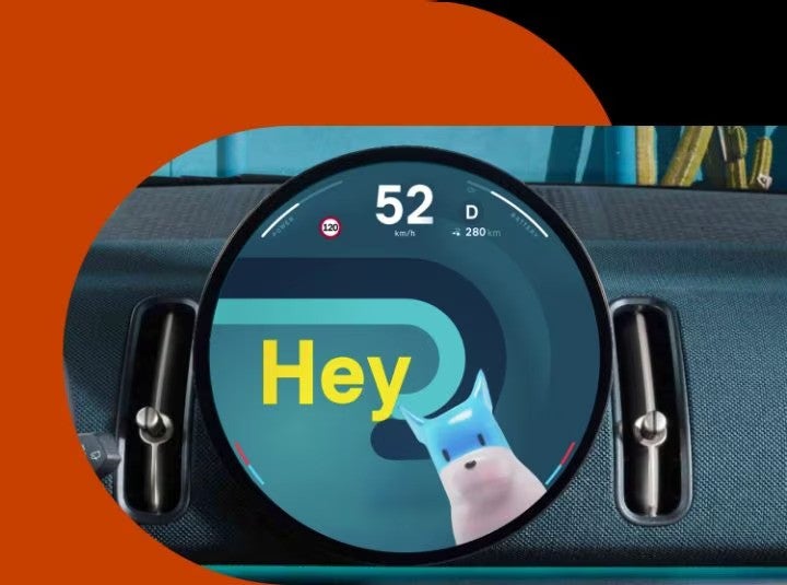 Closeup view of the MINI Countryman S ALL4 dashboard and 9.4” round center information OLED display with Spike on the screen.