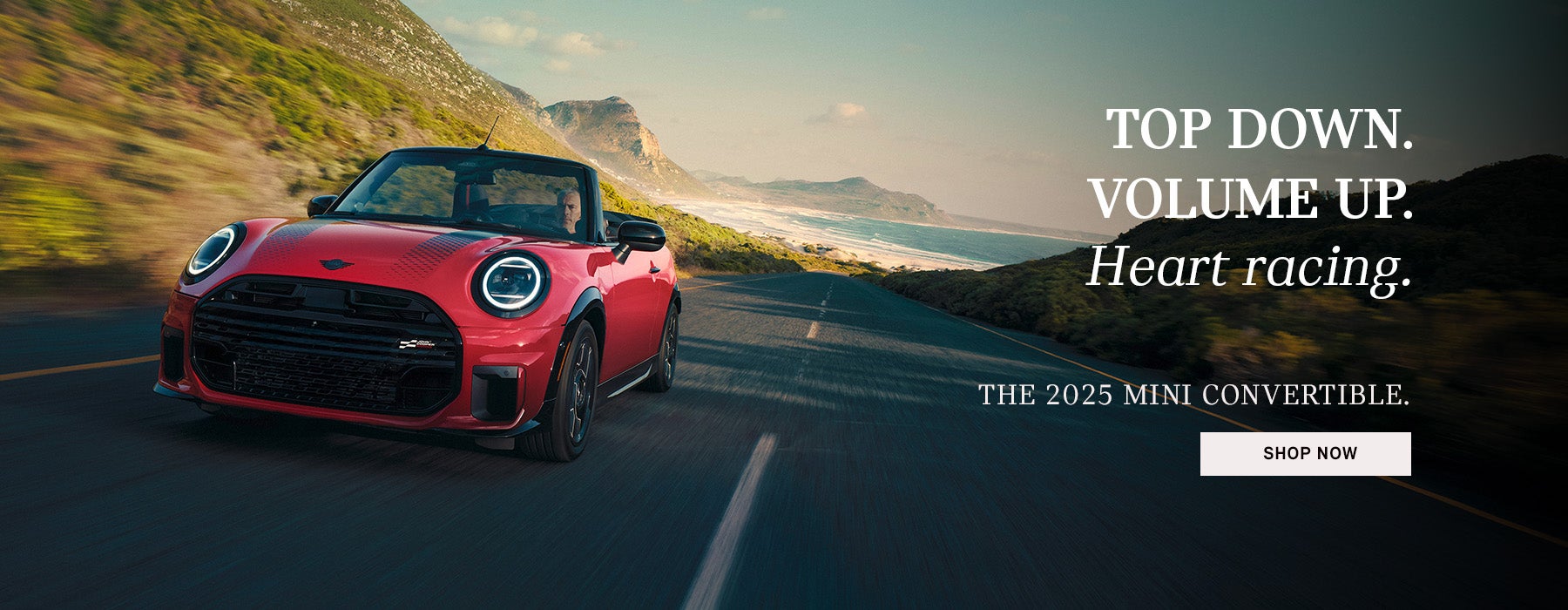 Red MINI Cooper S Convertible driving with a dropped top. 